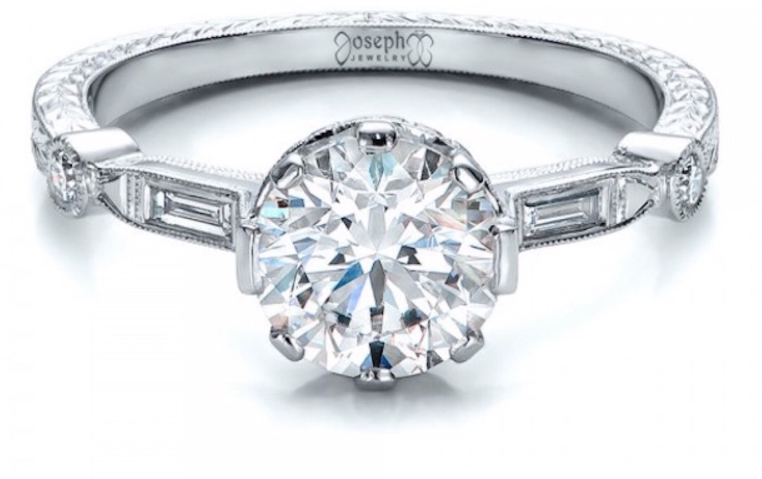 White gold engagement ring with large round center stone and baguette diamonds all around the band. 