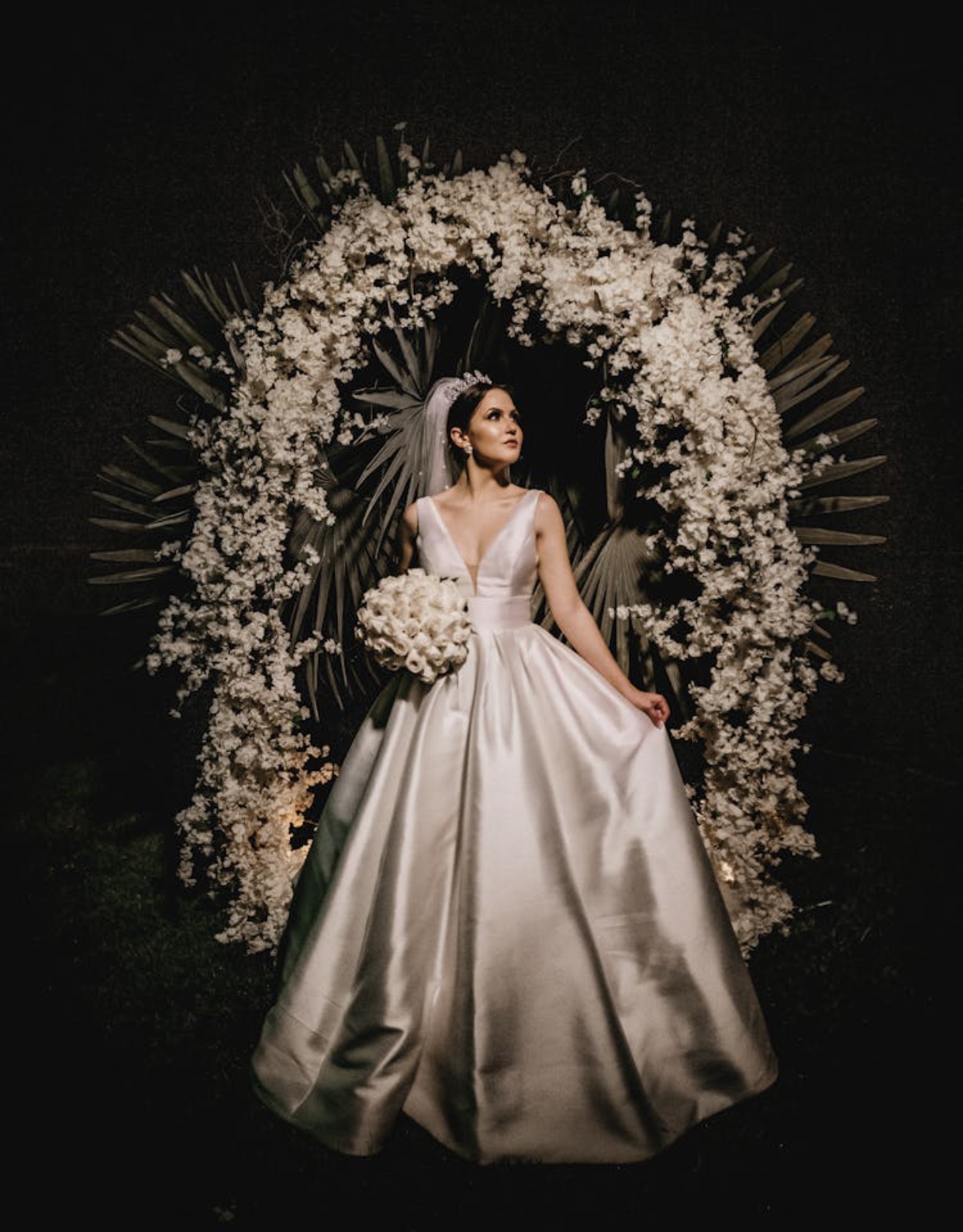 Brunette bride in a satin ivory gown with a plunging v-neckline and full skirt. 