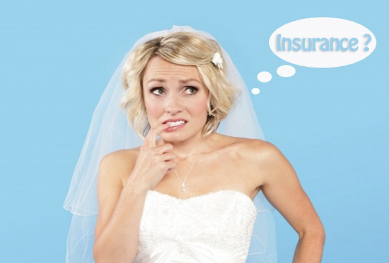 Concerned bride wearing a sheer veil and strapless white dress biting her finger thinking about insurance. 