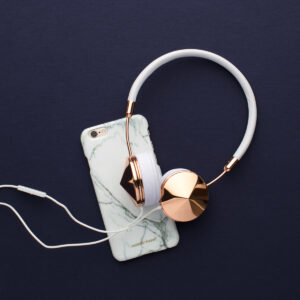 Gold and white headphones with a cell phone 