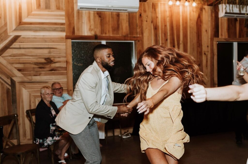 Guests dancing at a summer wedding at Steel Magnolia Barn