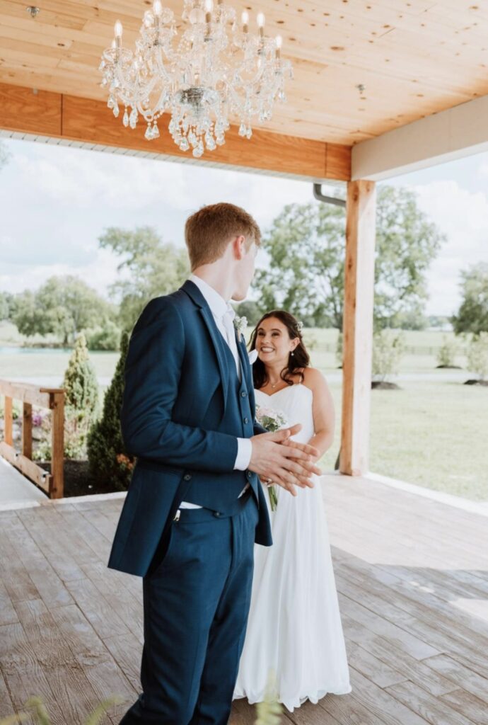 The bride smiles up at the groom during their their first look at Steel Magnolia Barn