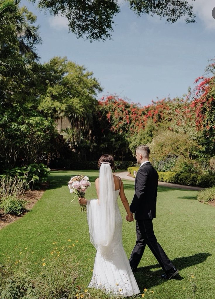 A bride and groom stroll through Centennial Park Sunken Garden in springtime.