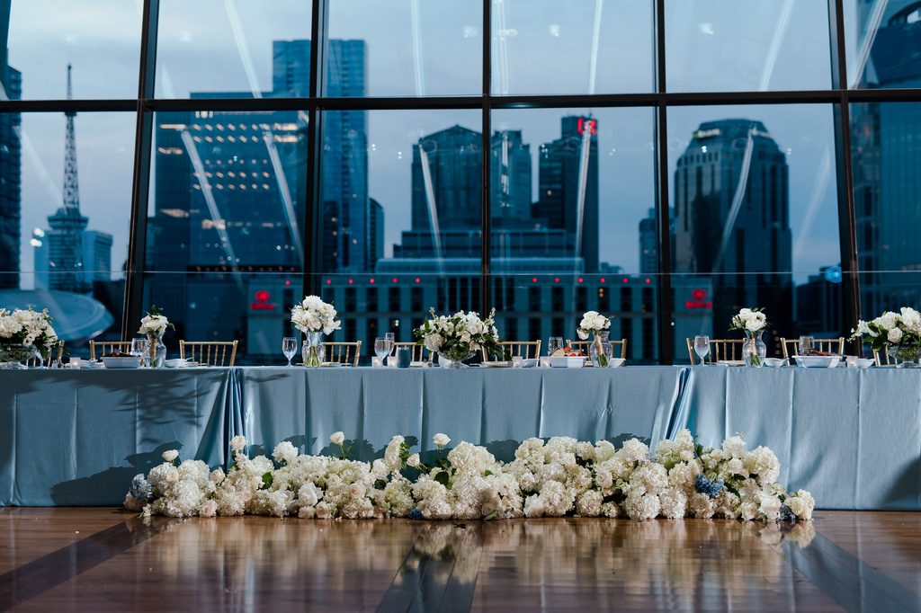 An evening view of Nashville at an elegant blue and white wedding at The Country Music Hall of Fame in Nashville, Tennessee. Featuring hardwood floors and floor to ceiling windows. 