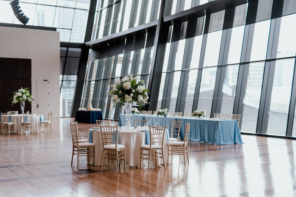 An elegant blue and white wedding at The Country Music Hall of Fame in Nashville, Tennessee featuring hardwood floors and floor to ceiling windows. 