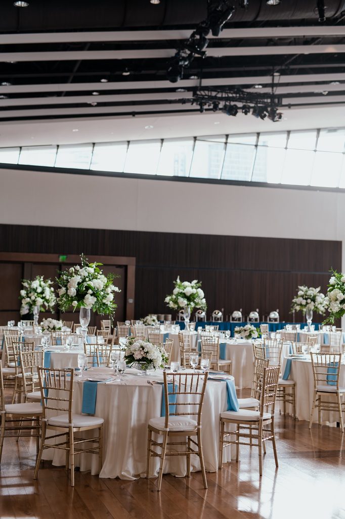 An bespoke blue and white wedding at The Country Music Hall of Fame in Nashville, Tennessee featuring hardwood floors and floor to ceiling windows. 