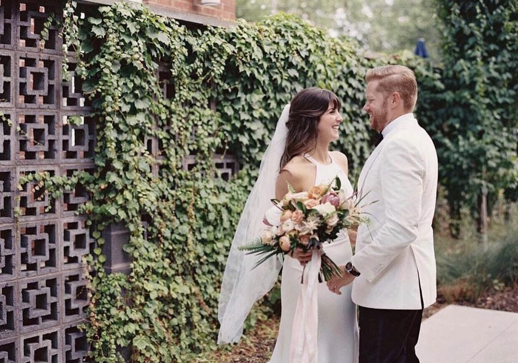 Bride and groom embracing in front of an ivy wall at The Clementine Nashville