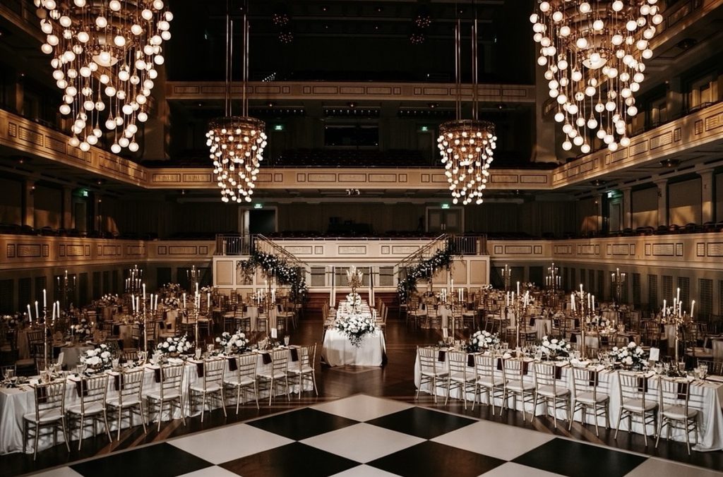Beautiful wedding reception with tall floral arrangements and chandeliers at the Schermerhorn Symphony Center in Nashville, Tennessee