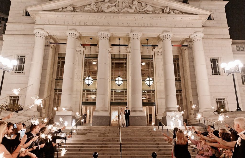 The exterior of the Schermerhorn Symphony Center in Nashville, Tennessee with a bride and groom descending the steps