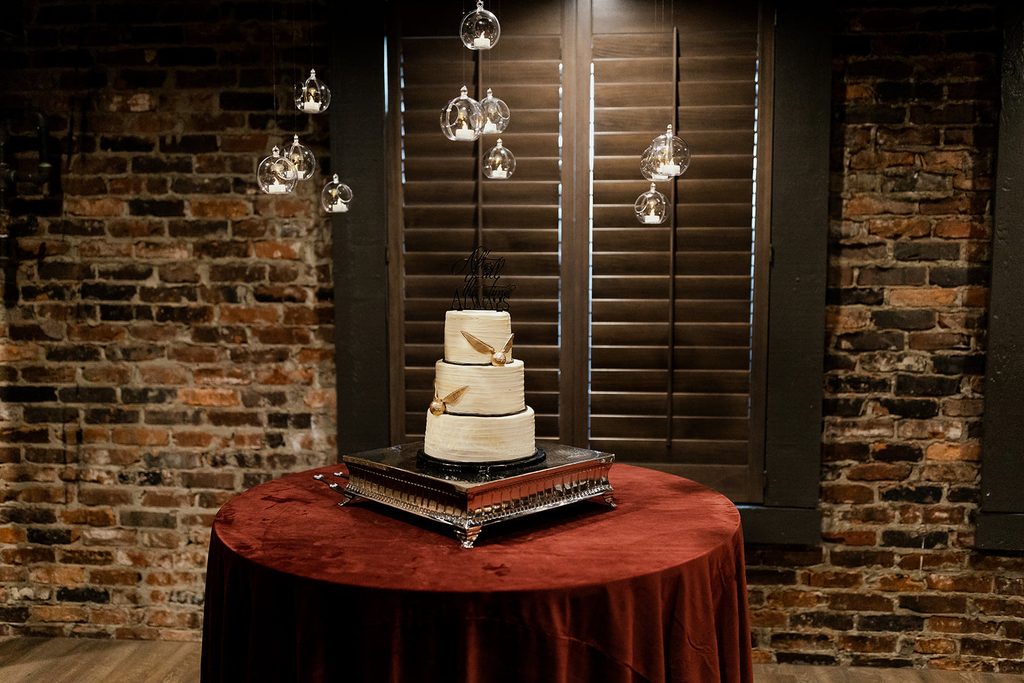 Harry Potter wedding cake at The Bedford Nashville Event Venue with exposed brick background. 