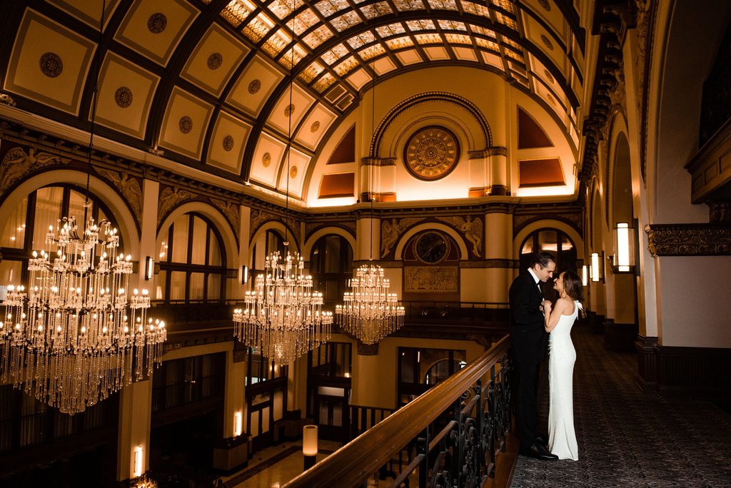 The bride and groom steal a kiss on the mezzanine at Union Station Nashville Yards in Nashville, Tennessee