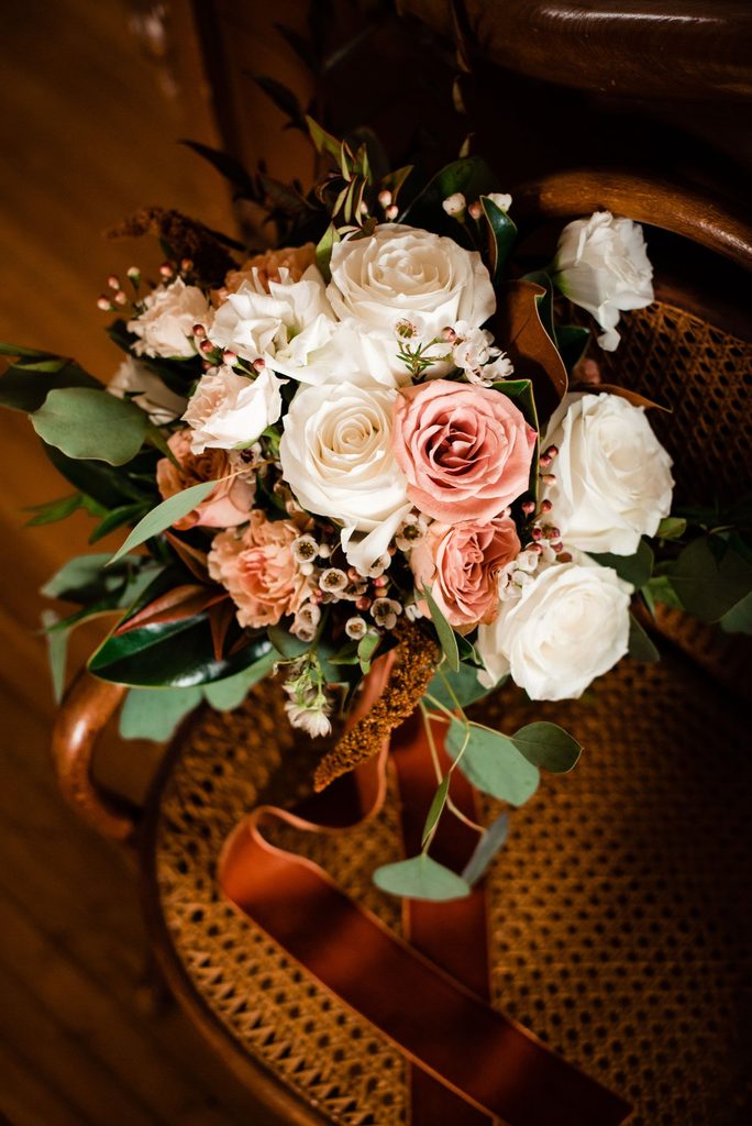 ivory and peach bouquet wrapped in a rust colored velvet ribbon