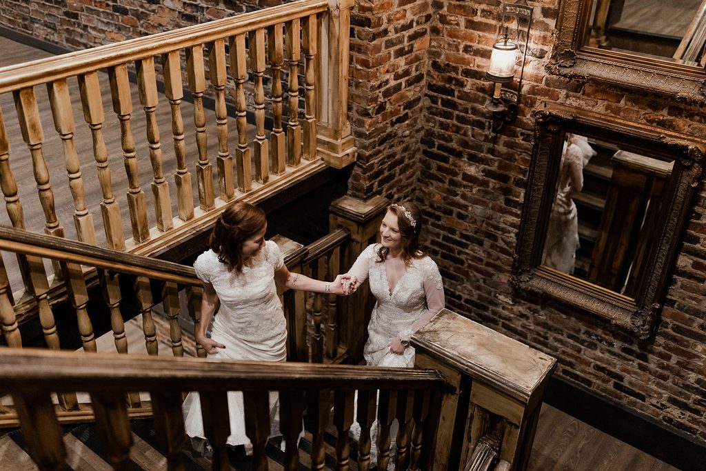 Two brides walking up the stairs at The Bedford Nashville Event Venue