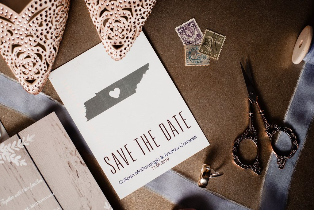 Save the Date card featuring the state of Tennessee and a heart over Nashville with vintage stamps and the edge of the bride's cowboy boots